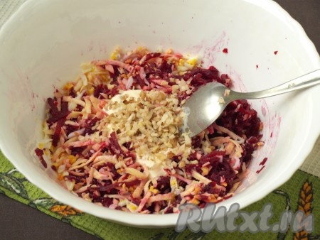 Нарубить грецкие орехи. Заправить салат сметаной, добавить половину орехов и измельчённый чеснок. По желанию, салат можно заправить майонезом или смешать пополам майонез со сметаной.
