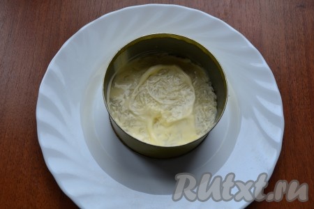 Для порционной подачи салат укладывать слоями на тарелку с помощью кулинарного кольца или обрезанной консервной банки. Первым слоем выложить очищенный и натертый на мелкой терке картофель, который чуть посолить и смазать майонезом.