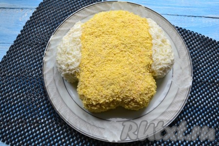 Далее всю мордочку собаки, кроме ушек, засыпать натертым на мелкой терке вареным желтком, а ушки покрыть частью натертого белка, который мы оставляли для украшения.
