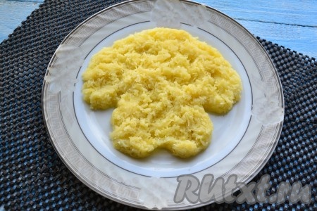 На большую плоскую тарелку выложить половину очищенного и натертого на средней терке отварного картофеля в виде собачьей мордочки с ушками.
