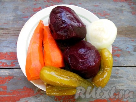 Свеклу и морковь заранее отварите до готовности (готовые вареные овощи должны легко прокалываться вилкой), охладите. Очистите свеклу, морковь и лук, у огурчиков обрежьте кончики.
