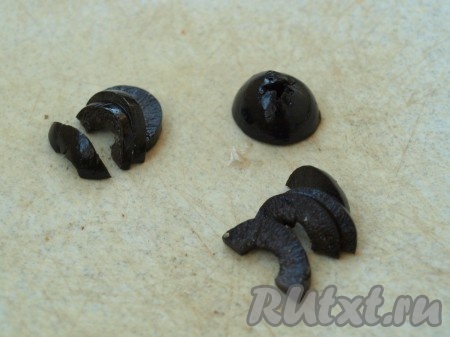 Каждую маслинку разрезать пополам поперёк. Верхняя часть маслины, на которой звездообразное отверстие, пойдёт на туловище, из оставшихся частей вырезать голову и лапы.
