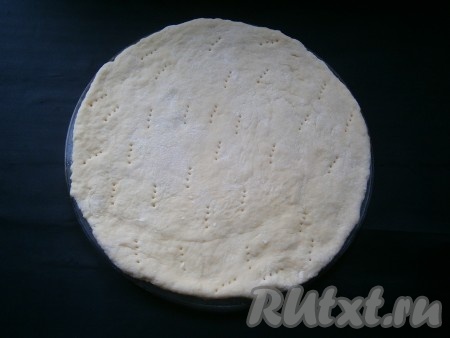 Затем тесто немного обмять и раскатать в лепешку по диаметру стеклянной тарелки из микроволновки. Поместить лепешку на эту же, смазанную чуть растительным маслом тарелку. Поколоть лепешку вилкой. Поместить основу в микроволновку на 5 минут при мощности 750 Ватт.