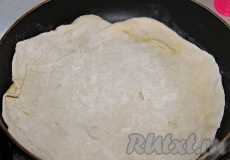 Отщипывая кусочек теста и на столе, присыпанном мукой, раскатываем его в достаточно тонкий корж (размер раскатанного коржа должен быть, примерно, равен диаметру сковороды, в котором он будет в дальнейшем подсушиваться), а затем слегка подсушиваем его на сухой сковороде на небольшом огне с двух сторон.
