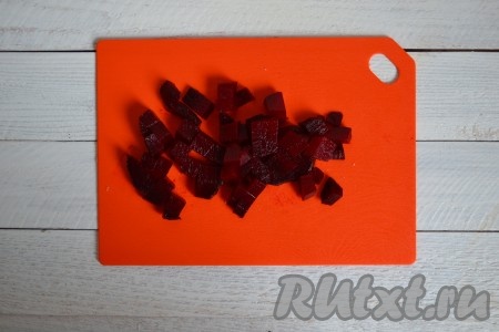 Вымыть свеклу, выложить в кастрюлю и доверху залить водой, поставить на огонь и варить до готовности. Для этого понадобится от 30 минут до 1,5 часов, в зависимости от размеров корнеплода. Чем крупнее свекла, тем дольше понадобится времени для варки. Очищать свеклу перед варкой и солить не нужно! Готовность можно проверить тонким лезвием ножа: если входит легко - свекла готова. Далее необходимо слить воду и дать свекле остыть. Затем очистить ее и нарезать крупным кубиками размером, примерно, 1х1 см.
