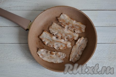 Когда бекон обжарится до румяного цвета с одной стороны, перевернуть его на другую сторону. На обжаривание бекона уйдет 2-3 минуты.