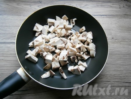 Шампиньоны нарезать кусочками, выложить на разогретую с растительным маслом сковороду, обжарить их на среднем огне в течение 5 минут, периодически перемешивая.
