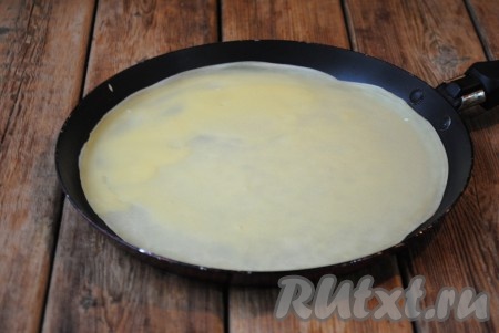 Перед выпеканием первого блина немного смазать сковороду растительным маслом. На сковороду налить небольшое количество теста, равномерно распределяя его по поверхности сковороды, и жарить блин на среднем огне 1-1,5 минуты (до золотистого цвета), затем перевернуть на другую сторону и поджарить до золотистого цвета с другой стороны. Готовый блинчик переложить со сковороды на тарелку. Аналогично пожарить все блины. В итоге должно получиться 6-7 блинов.
