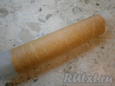 Свернуть бисквит вместе с пергаментом в рулет и оставить его в таком положении до полного остывания.