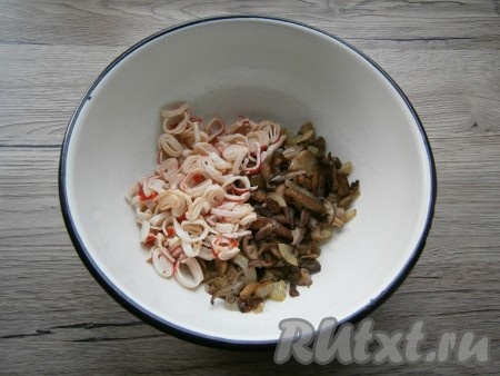 Жареные крабовые палочки остудить, выложить в миску, добавить к ним остывшие грибы.
