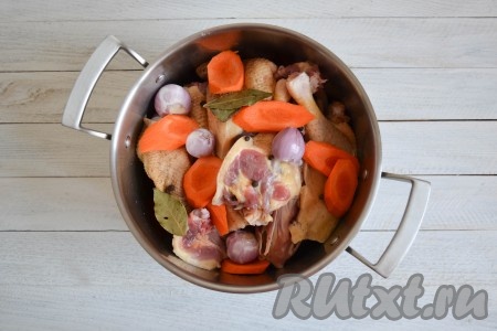 Гуся тщательно вымыть, разрезать на небольшие части. В большую 7-литровую кастрюлю выложить кусочки гуся, лавровые листики, горошины черного перца, очищенные луковицы, очищенную и нарезанную на кусочки морковь.
