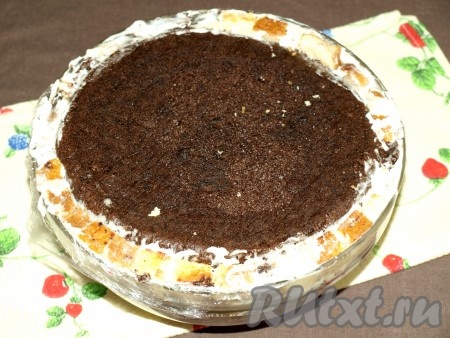 Когда останется мало кусочков бисквита, выложить сверху целый бисквитный шоколадный корж, который мы отложили. У меня остался небольшой промежуток между формой и шоколадным бисквитом, в него я поместила оставшиеся кусочки бисквита. Тут нужно смотреть по размеру формы, возможно, что бисквитов может быть много, тогда их можно использовать для другого десерта.
