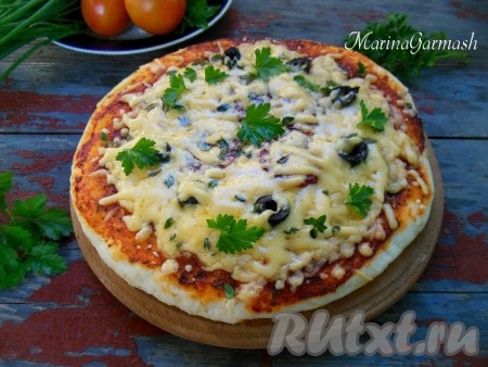 Выпекайте пиццу в разогретой духовке при температуре 180 градусов 10-12 минут. Горячую пиццу после духовки я всегда дополнительно поверх начинки посыпаю натёртым сыром. Готовую пиццу переложите на доску, дайте слегка остыть, нарежьте на кусочки и подавайте к столу.