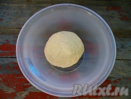 Замесите тесто. Замешивается тесто очень легко и быстро. Тесто для пиццы, замешанное на молоке без добавления дрожжей, получается мягким, легко отлипает от рук. Скатайте тесто в шар, заверните в пищевую пленку или пакет и оставьте на 15-20 минут. За это время можно подготовить начинку: натереть сыр и нарезать колбасу. Через 15-20 минут достаньте тесто из пакета. Я делю тесто на две части и выпекаю две небольших пиццы диаметром 19 см. Можно и не делить тесто на две части. Слегка раскатайте тесто на столе, присыпанном мукой, затем перенесите на противень, смазанный растительным маслом или покрытый пергаментом.