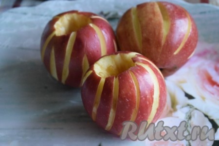 Для того чтобы яблоки лучше пропеклись, сделать надрезы по кожуре яблок при помощи ножа. Надрезы нужны и для того, чтобы яблоки, при поливке мёдом, хорошо пропиталось не только изнутри, но и снаружи (этот шаг можно&nbsp; пропустить, если яблоки сладкие и не требуют дополнительного подслащивания).
