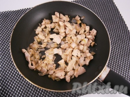 Обжарить куриное филе на сковороде на растительном масле, помешивая, до изменения цвета. Лук очистить, нарезать средними кусочками и выложить на сковороду к обжаренному мясу, посолить, поперчить. Обжаривать курицу с луком в течение 5-7 минут на среднем огне, периодически перемешивая.
