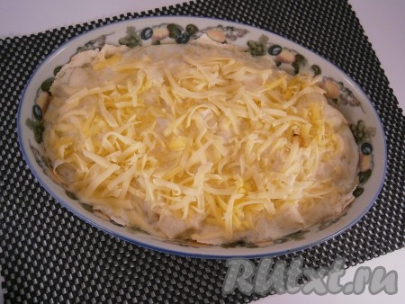 Запекать пирог из лаваша с курицей и сыром в разогретой духовке при температуре 180 градусов 10 минут, после чего пирог достать и посыпать его оставшимся сыром.