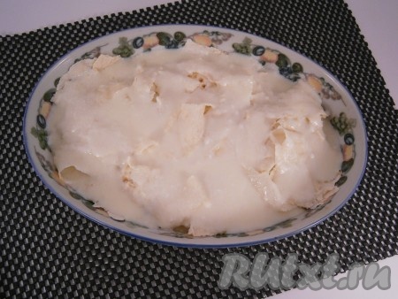 Второй лаваш также порвать на небольшие части и покрыть им курицу с сыром. Вылить сверху оставшуюся заливку.
