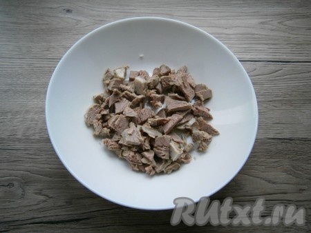 Для того чтобы отварить говядину, мясо нужно нарезать на куски, поместить в кастрюлю, залить полностью водой, поставить на огонь и после закипания, снизив огонь к минимуму, варить до готовности (45-50 минут). Отварную говядину остудить и нарезать на небольшие кусочки.