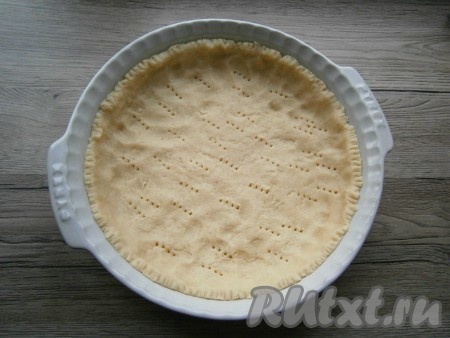 Тесто раскатать и поместить его в форму диаметром 24-26 см, формируя бортики. Наколоть тесто вилкой и отправить в разогретую до 180 градусов духовку на 20-25 минут.
