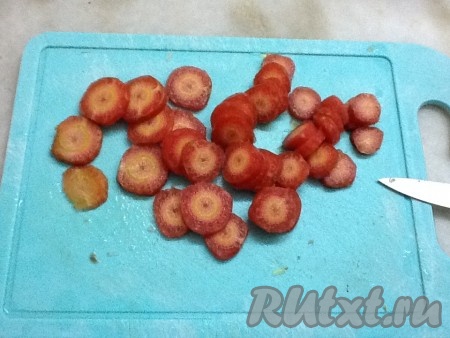 Нарезать очищенную морковь кружочками и добавить в кастрюлю.