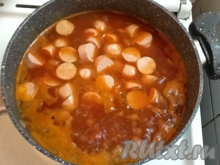 Нарезаем сосиски и отправляем вслед за квашеной капустой и томатом.