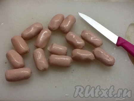 Нарезаем сосиски и отправляем вслед за квашеной капустой и томатом.