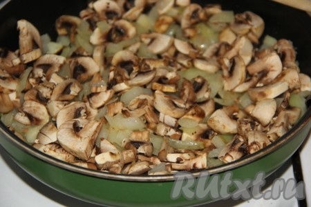Шампиньоны промыть под проточной водой и нарезать на тонкие пластинки. Добавить грибы в сковороду к луку и обжарить в течение 10 минут, помешивая.
