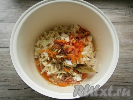 Добавить в чашу мультиварки к капусте и колбасе томатную пасту, соль, специи, сахар, лавровый лист и влить оставшуюся воду.
