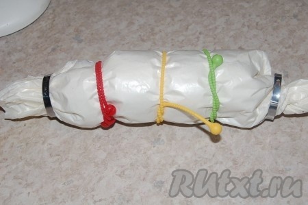 Затем пергамент крепко стянуть и связать полученный рулет. Очень удобно пользоваться специальными штучками для рулетов. А также можно воспользоваться бечевкой или обычными крепкими нитками. Главное - как следует стянуть, чтобы как можно меньше воды попало внутрь при варке.