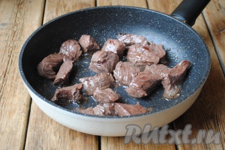Сковороду с растительным маслом разогреть и выложить туда кусочки говядины. Обжарить мясо на сильном огне до лёгкой корочки со всех сторон (в течение 5-7 минут).&nbsp;
