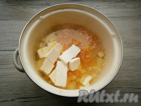 Овощи обжарить 4-5 минут на среднем огне, помешивая, затем добавить их в кастрюлю с готовым картофелем. Сюда же добавить нарезанный кубиками сливочный плавленный сыр.
