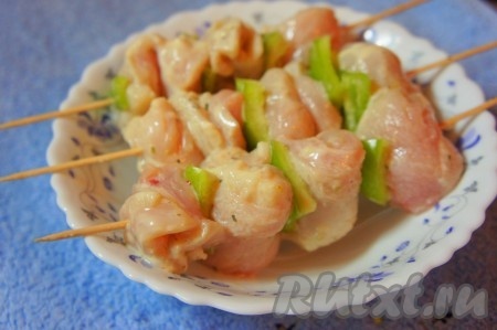 Шпажки заранее замочить в воде (чтобы не подгорели при приготовлении) минут на 30. Болгарский перец нарезать на кусочки. На шпажки, чередуя, надеть кусочки замаринованного куриного филе и кусочки болгарского перца.
