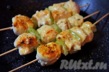 Обжарить куриные шашлычки на шпажках с 4 сторон на среднем огне на хорошо разогретой сковороде с добавлением небольшого количества растительного масла. Обжаривайте их, примерно, по 1 минуты с каждой стороны (до образования золотистой корочки), но при этом до состояния полуготовности. Затем форму для запекания смазать растительным маслом, выложить в форму куриное филе на шпажках и отправить в хорошо разогретую духовку. Запекать при температуре 180-200 градусов в течение 20 минут (время указано ориентировочно, всё зависит от того, как вы нарезали мясо).