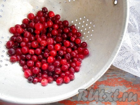 Ягоды клюквы промойте под проточной водой, выложите на дуршлаг, чтобы стекла лишняя жидкость. Можно дополнительно просушить на полотенце.
