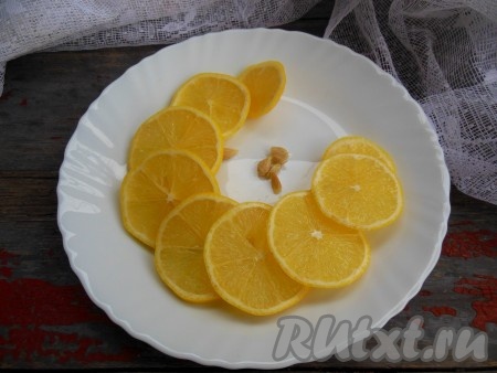 Лимон обдайте кипятком, нарежьте на колечки с кожурой, удалите косточки.