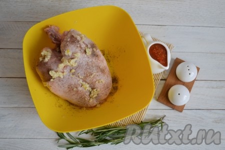 Куриную грудку вместе с костью и кожей вымыть, обсушить салфетками и натереть солью и черным молотым перцем. Очистить чеснок, пропустить его через пресс и тщательно натереть им мясо.
