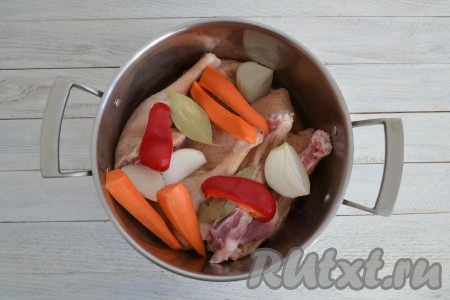 Из перца удалить семенную коробку, лук и морковку очистить. Выложить крупно нарезанный лук, морковь, сладкий болгарский перец и лавровые листья в кастрюлю с кусочками гуся.
