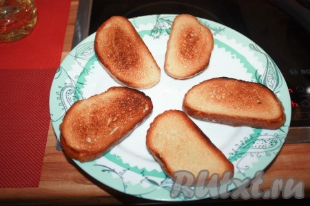 Дольку чеснока разрезать пополам и натереть половинками одну сторону каждого ломтика, на которую будет выкладываться намазка.