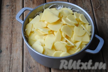 По истечении этого времени выложить к капусте и фаршу картофель, нарезанный кружочками или полукружочками.
