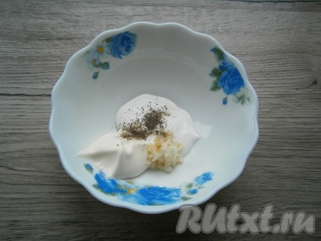 К майонезу добавить сметану, пропущенный через пресс чеснок, немного соли и черного молотого перца.