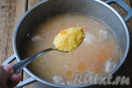 Когда мясо сварится (станет мягким), выложить к овощам и мясу кукурузную крупу, варить кашу, не накрывая крышкой, на небольшом огне в течение 10-15 минут, постоянно помешивая.
