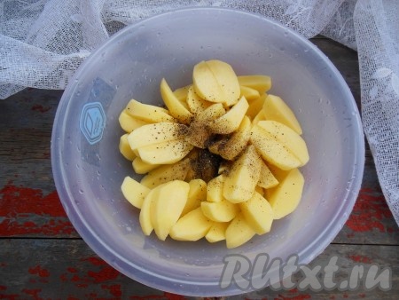 Очистите картофель от кожуры, разрежьте на 4 части, добавьте соль и перец по вкусу, влейте 1 чайную ложку растительного масла, перемешайте.
