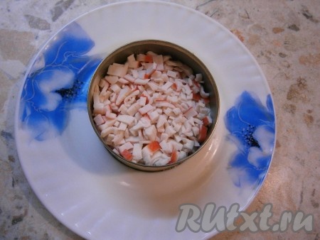 Следующий слой - мелко нарезанные крабовые палочки + немного майонеза.
