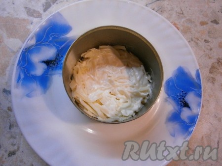 Первым слоем выложить натертый на крупной терке любой мягкий или полутвердый, но не слишком соленый сыр. Смазать сыр майонезом.