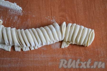 Острым тонким ножом нарезать рулет из теста на кусочки шириной 4-5 мм.
