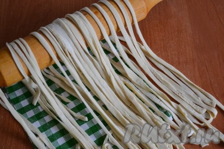 Затем необходимо каждый свернутый кусочек развернуть, при этом стряхивая излишки муки. Теперь домашнюю лапшу, приготовленную без добавления яиц и молока, можно варить, а можно высушить, чтобы использовать, когда будет необходимо. Для того чтобы высушить лапшу, её нужно выложить на поверхность (например, на стол, застеленный пергаментом), чтобы она свободно лежала (кусочки лапши не должны слипнуться между собой в процессе высыхания) и оставить при комнатной температуре, примерно, на сутки, за это время лапшу можно 1-2 раза аккуратно перемешать. Сухая лапша должна стать жесткой и ломкой, затем её необходимо сложить в герметичный контейнер и можно хранить около месяца.
