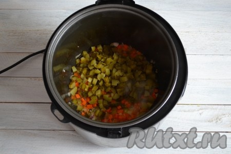 Когда лук с морковью станут мягкими, выложить к ним соленые огурцы, нарезанные мелкими кубиками, перемешать и обжаривать 2-3 минуты на функции "Жарка", помешивая.