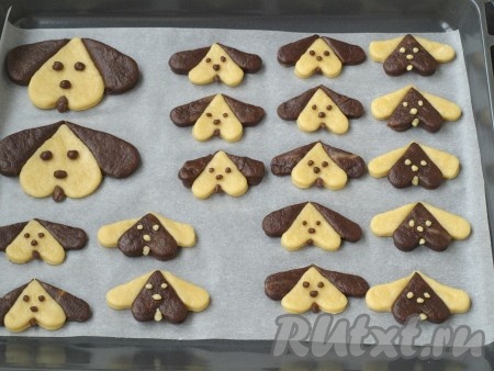 Из остатков теска скатать глазки, носики и язычки. Застелить пергаментом противень, разложить заготовки, приставить глазки, носики и язычки.
