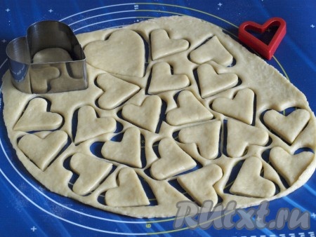 Затем раскатать поочерёдно каждую часть теста в пласт толщиной 5 мм. С помощью формочки "сердце" вырезать заготовки печенья.

